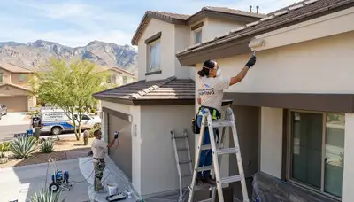 Professional house painters working on residential exterior in Tucson, AZ